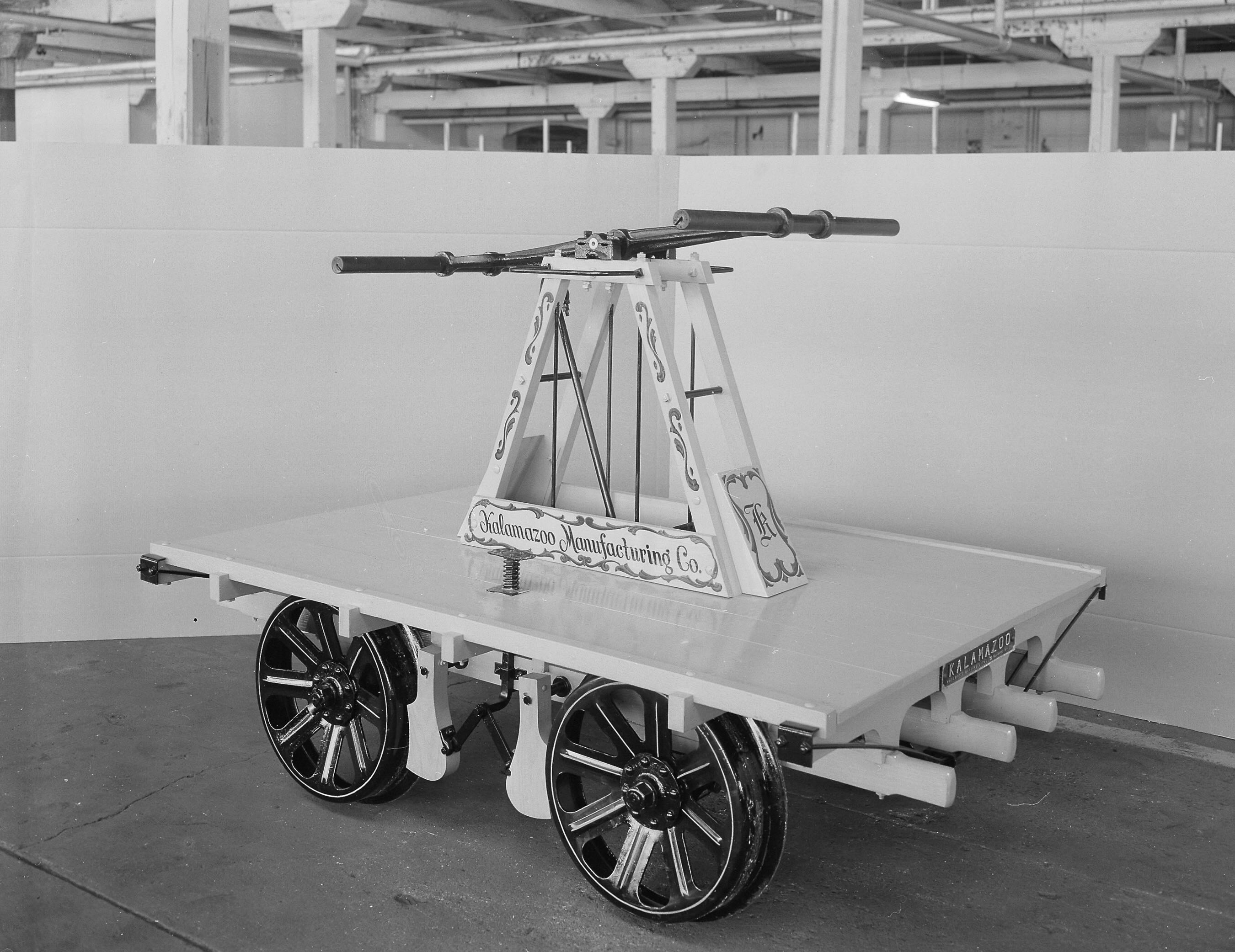 A decorated railroad handcar in a warehouse space